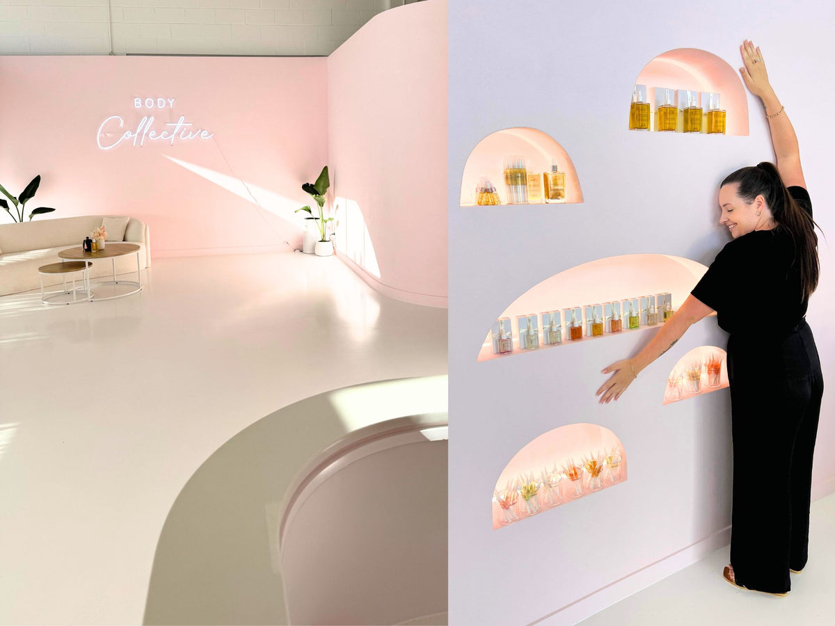 Salon interior with a neon sign, and a nail tech arranging nail serum bottles on an arched retail display wall